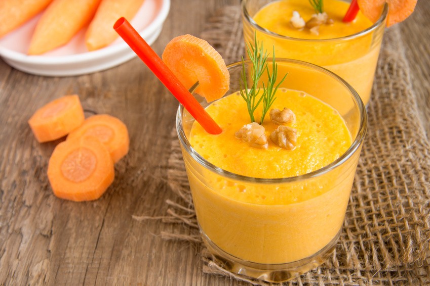 Carrot smoothi with nuts on wooden background, horizontal close up