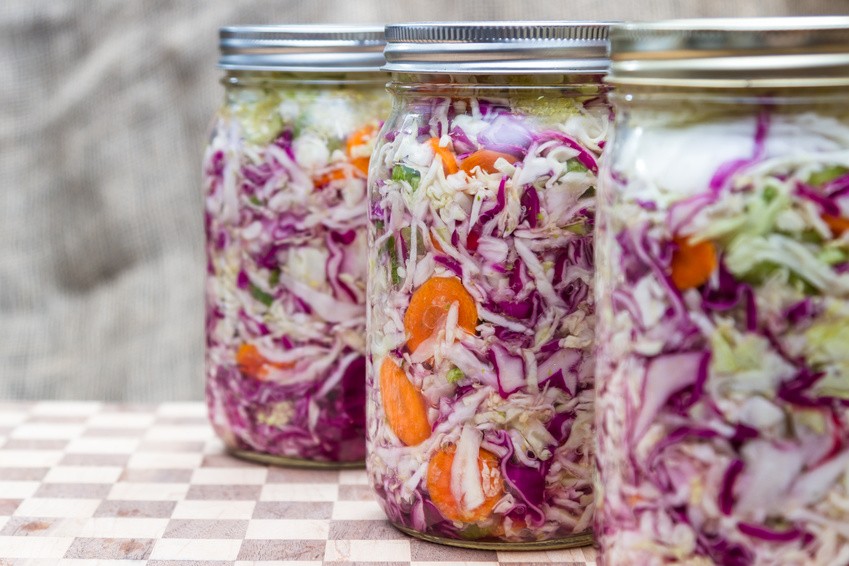home made cultured or fermented vegetables in jars with more in the background